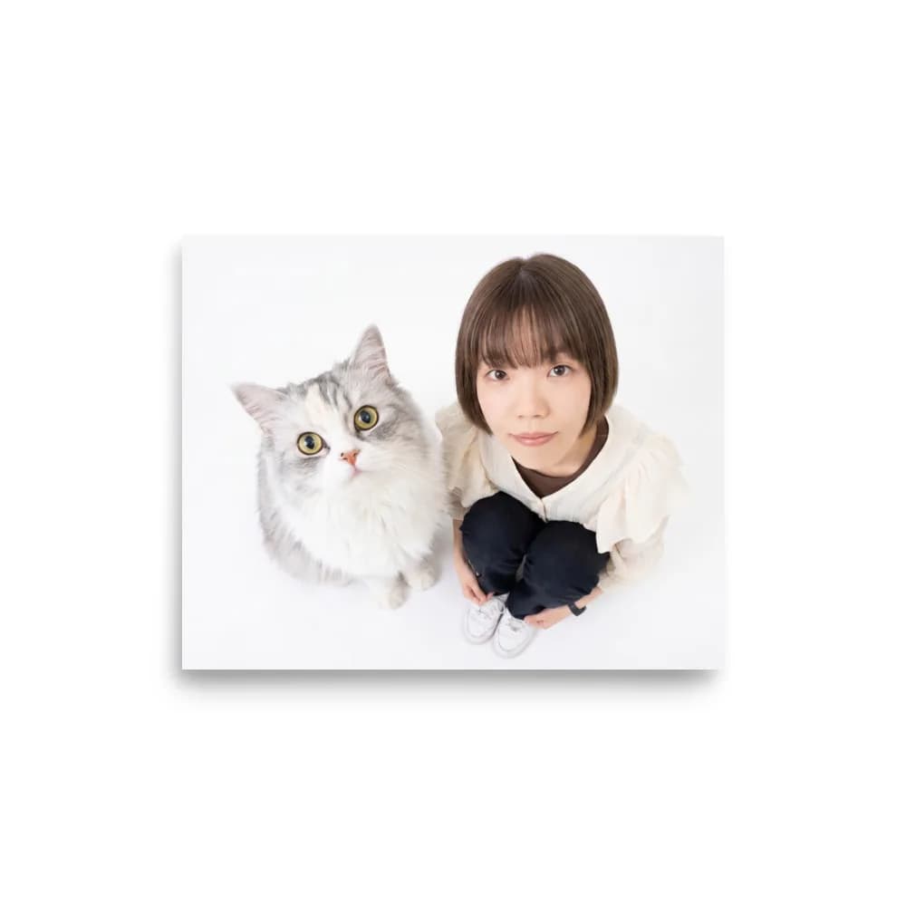 Front view of the luster photo paper poster laid flat, showing an overhead photo of a young woman sitting beside her silver long-haired cat, both looking up
